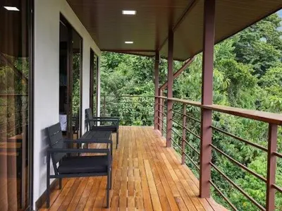 two benches sitting on a porch of a house at VILLA SANTA LUCÍA in front of the waterfall with a mountain view in Ceibo