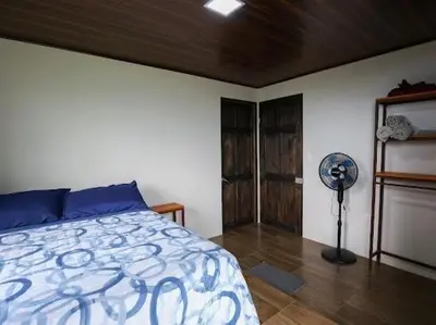 a bedroom with a bed and a fan at VILLA SANTA LUCÍA in front of the waterfall with a mountain view in Ceibo