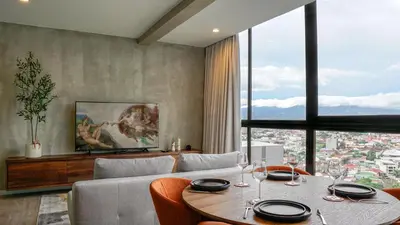 a living room with a table and a couch at Zen Urbano View of the Irazu Volcano con Jacuzzi and AC in Curridabat