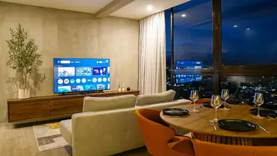 a living room with a table and a television at Zen Urbano View of the Irazu Volcano con Jacuzzi and AC in Curridabat