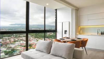 a living room with a couch and a table at Zen Urbano View of the Irazu Volcano con Jacuzzi and AC in Curridabat