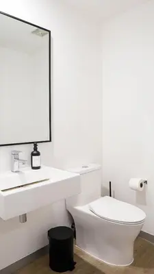 a white bathroom with a sink and a toilet at Zen Urbano View of the Irazu Volcano con Jacuzzi and AC in Curridabat