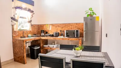 a kitchen with a table and a refrigerator at Toucan Villa Rio Cuarto in Río Cuarto