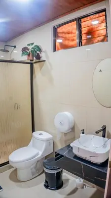 a bathroom with a toilet and a sink at Toucan Villa Rio Cuarto in Río Cuarto