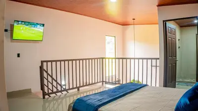 a bedroom with a bed and a tv on the wall at Toucan Villa Rio Cuarto in Río Cuarto