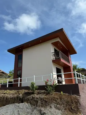 a small house with a balcony on a hill at Toucan Villa Rio Cuarto in Río Cuarto
