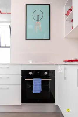 a kitchen with white cabinets and a black dishwasher at Lovely space - awesome San Jose view from 26th fl in San José
