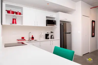 a kitchen with white cabinets and a refrigerator at Lovely space - awesome San Jose view from 26th fl in San José