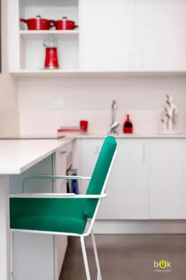 a green chair in a white kitchen with a sink at Lovely space - awesome San Jose view from 26th fl in San José
