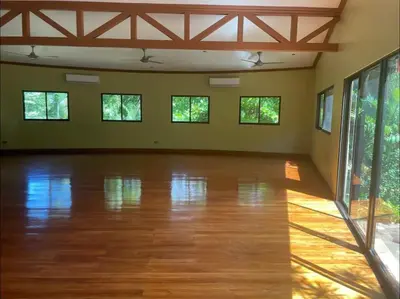 an empty room with a wooden floor and windows at Casa La Junglita in Paraíso
