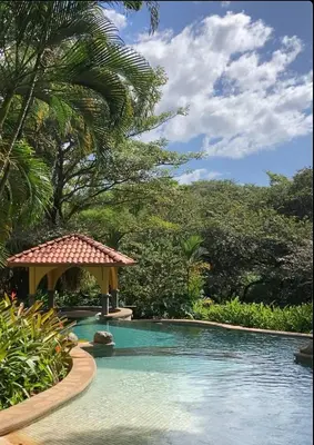 a swimming pool with a gazebo and trees at Casa La Junglita in Paraíso
