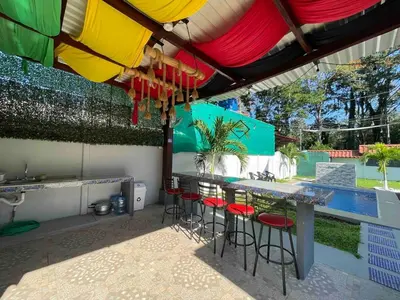 a patio with a table and chairs under an umbrella at Villa del Sol house with pool & AC in Tapantí