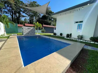 a swimming pool in front of a house at Villa del Sol house with pool & AC in Tapantí