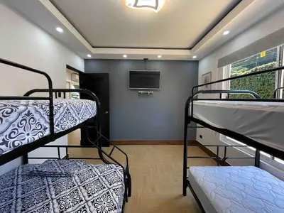 a room with two bunk beds and a flat screen tv at Villa del Sol house with pool & AC in Tapantí