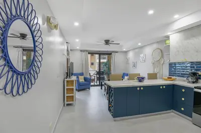a kitchen with blue cabinets and a mirror on the wall at 2 Bedroom Oceanview Beachfront Condo Jaco Beach in Jacó