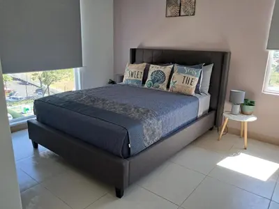 a bedroom with a large bed with pillows and a window at A short walk from the sea - 2 bedrooms - 2 beds - 2 bathrooms in Jacó