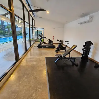 a gym with treadmills and exercise bikes in a room at A short walk from the sea - 2 bedrooms - 2 beds - 2 bathrooms in Jacó
