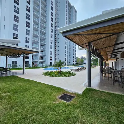 a patio with tables and chairs and buildings at A short walk from the sea - 2 bedrooms - 2 beds - 2 bathrooms in Jacó