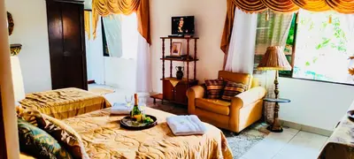a living room with a bed and a chair and a table at Casa para grupos grandes 28 huéspedes in Santo Domingo