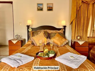 a bed with a bowl of grapes and wine glasses at Casa para grupos grandes 28 huéspedes in Santo Domingo