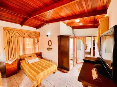 a bedroom with a bed and a flat screen tv at Casa para grupos grandes 28 huéspedes in Santo Domingo