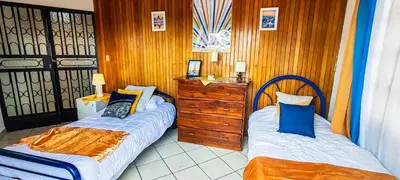 a bedroom with two beds and a dresser at Casa para grupos grandes 28 huéspedes in Santo Domingo