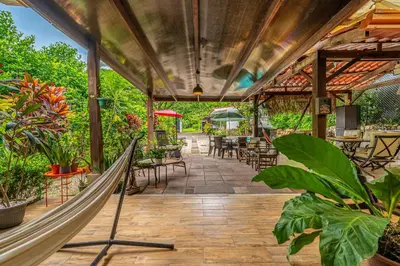 a hammock on a patio with tables and chairs at Tiburon Galano - Playa Carrillo in Carrillo