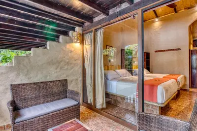 a master bedroom with a bed and a balcony at Ylang Ylang Beach Resort in Montezuma