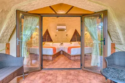 a room with a bed and glass doors at Ylang Ylang Beach Resort in Montezuma