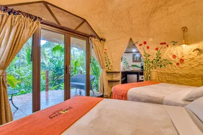 a bedroom with two beds and a large window at Ylang Ylang Beach Resort in Montezuma