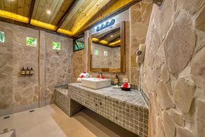a bathroom with a sink and a stone wall at Ylang Ylang Beach Resort in Montezuma