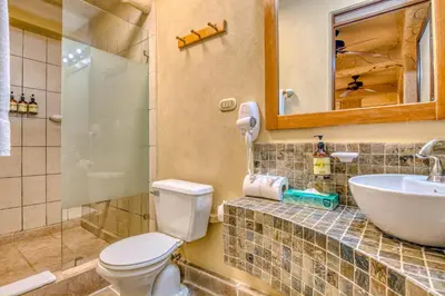 a bathroom with a toilet and a sink and a mirror at Ylang Ylang Beach Resort in Montezuma