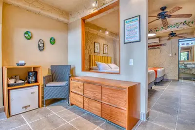 a room with a bedroom with a bed and a desk at Ylang Ylang Beach Resort in Montezuma