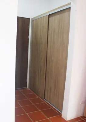 a room with wooden doors and a tile floor at Hotel El Arca, Jardín Botánico y Restaurante in Santa Bárbaraa