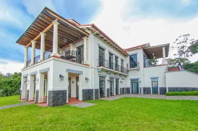 a large white house with a green yard at Hotel El Arca, Jardín Botánico y Restaurante in Santa Bárbaraa