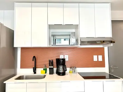 a kitchen with white cabinets and a sink at Luxurious 9th floor apartment in Vuelta del Virilla