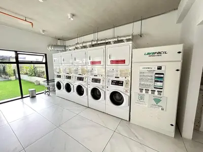 a laundry room with three washing machines and a window at Luxurious 9th floor apartment in Vuelta del Virilla