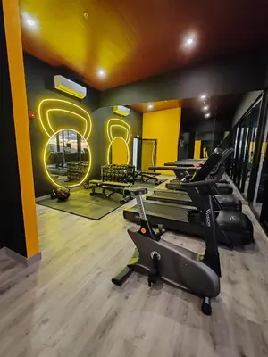 a gym with a row of treadmills and a sign at Fantastic 1607 Ser ESCALANTE in San José