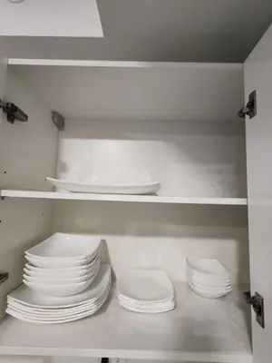 a stack of plates and bowls in a kitchen cabinet at Fantastic 1607 Ser ESCALANTE in San José