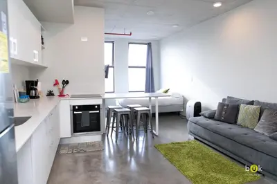 a kitchen and living room with a couch and a table at Sunset view URBN Studio 16th floor in San José