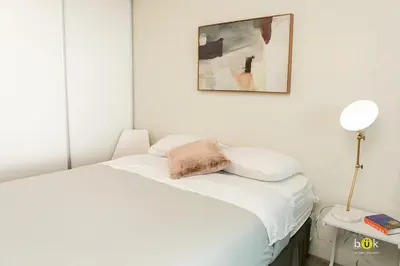 a white bedroom with a bed and a picture on the wall at INSTAWORTHY CORNER VIEW 200Mbps in San José