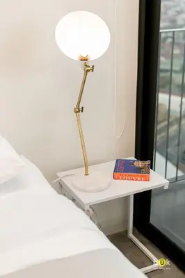 a lamp on a table next to a bed at INSTAWORTHY CORNER VIEW 200Mbps in San José