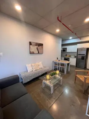 a living room with a couch and a table at INSTAWORTHY CORNER VIEW 200Mbps in San José