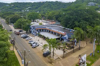 a blue building with cars parked in a parking lot at Club Voca #2 in Coco
