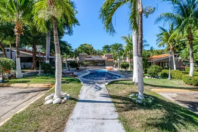 a driveway with palm trees in front of a house at Club Voca #2 in Coco