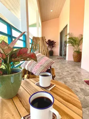 a table with a cup of coffee and a plant at Casa Nube, 3 mins to beaches in Sámara