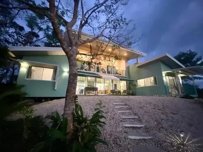 a house with a tree in front of it at Casa Nube, 3 mins to beaches in Sámara
