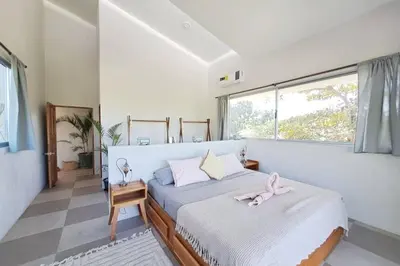 a bedroom with a bed with a pink ribbon on it at Casa Nube, 3 mins to beaches in Sámara