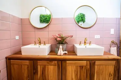 two sinks in a bathroom with pink tiles at Casa Nube, 3 mins to beaches in Sámara