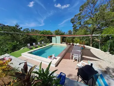 a swimming pool with chaise lounge chairs and a swimming pool at Casa Nube, 3 mins to beaches in Sámara